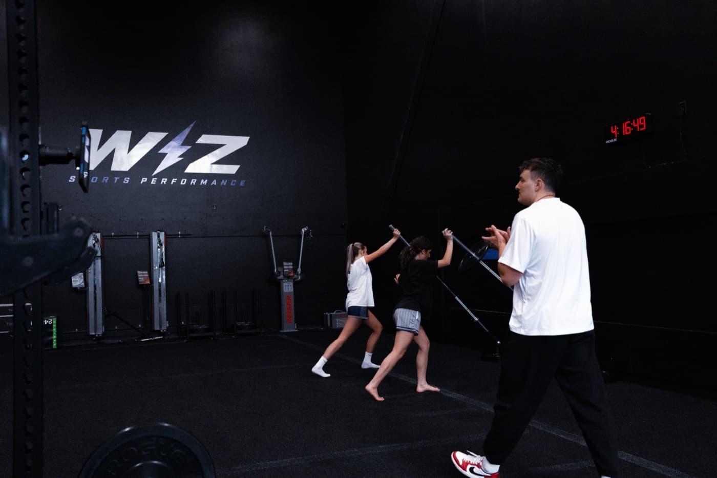 Athletes working through a resisted sprint drill with a coach